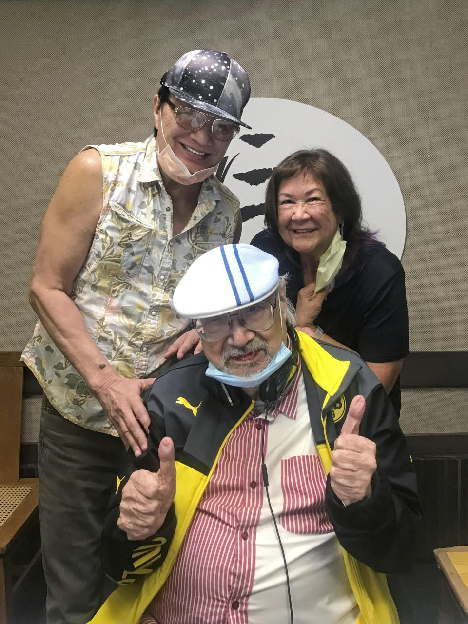 In this photo provided by Radio Television Hong Kong (RTHK), DJ, Ray Cordeiro, also known as Uncle Ray, center, poses with Hong Kong singer Sam Hui, left, and his wife Rebecca at the studio in RTHK, the broadcaster in Hong Kong on Feb. 14, 2021. After more than seven decades in radio, the 96-year-old Hong Kong DJ bid farewell to his listeners Saturday, May 15, 2021 with “Time to Say Goodbye,” sung by Sarah Brightman and Andrea Bocelli. (Radio Television Hong Kong via AP)