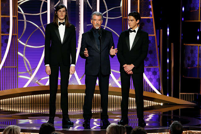 Dylan Brosnan with long hair standing with Pierce and Paris