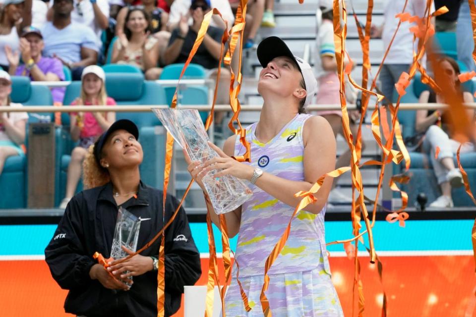 Iga Swiatek holds up the trophy after beating Naomi Osaka in the women’s singles final at the Miami Open (AP)