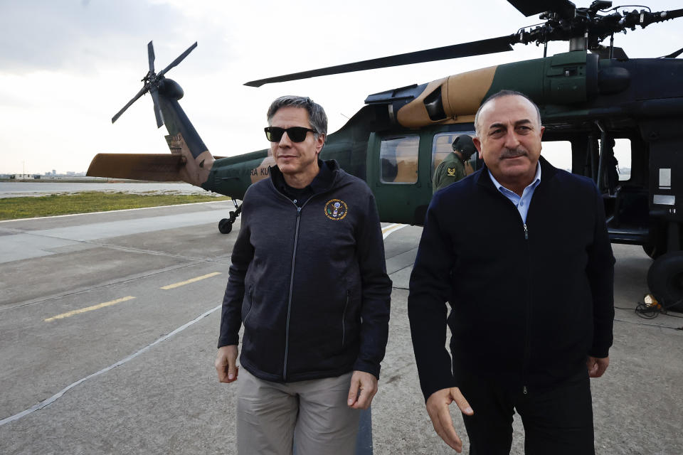 U.S. Secretary of State Antony Blinken, left, walks with Turkish Foreign Minister Mevlut Cavusoglu, following a helicopter tour of earthquake stricken areas of Hatay Province, at Incirlik Air Base near Adana, Turkey, Sunday, Feb. 19, 2023. (Clodagh Kilcoyne/Pool Photo via AP)