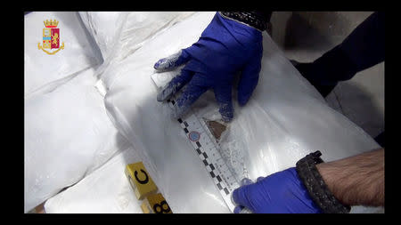 A police officer checks a bag of heroin found in Genoa harbour in this video grab provided by the Italian Police, November 8, 2018. Polizia Di Stato/Handout via REUTERS