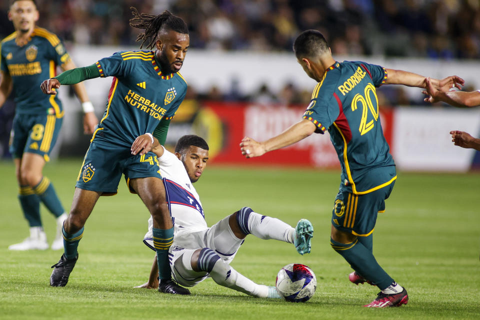Vancouver Whitecaps midfielder Pedro Vite, center, vies for the ball between LA Galaxy forward Raheem Edwards, left, and midfielder Memo Rodríguez during the second half of an MLS soccer match in Carson, Calif., Saturday, March 18, 2023. (AP Photo/Ringo H.W. Chiu)