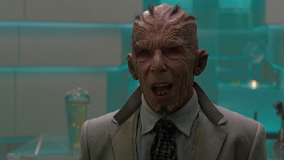 The Broker in his tie and jacket with his red skin and mini mohawk hair looks scared  in Guardians of the Galaxy Vol. 1