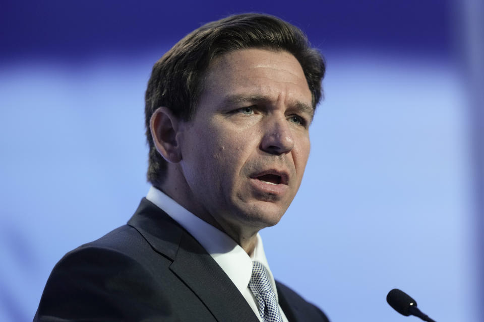 Florida Governor Ron DeSantis, who has been engaged in conflict with Disney, is shown speaking into a microphone.