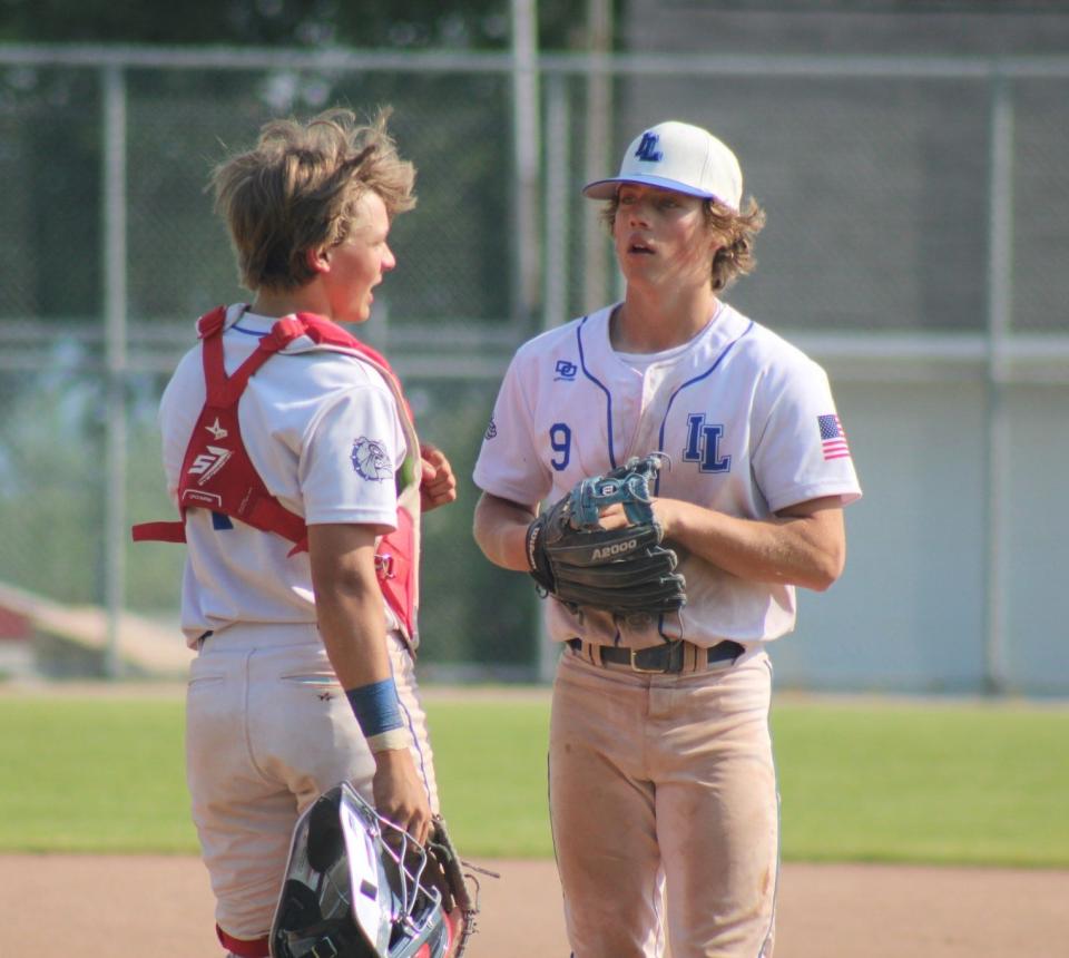 Inland Lakes' Connor Wallace (right) and Aidan Fenstermaker share a chat on the mound during a regional semifinal baseball game against Rudyard at Harbor Springs last season. The Bulldogs are aiming to capture a third consecutive Ski Valley Conference title this spring.