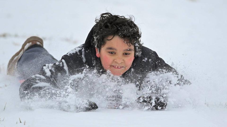 Nine-year-old Jace Stoddard of Kansas City sleds down a hill at Gillham Park. The two to four inches of snow that fell in the Kansas City area Saturday morning, Jan. 15, 2022, brought people out to play and enjoy the snow.