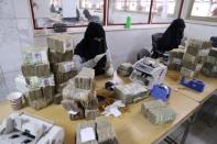 Employees count bundles of Yemeni Riyal at the Central Bank of Yemen in Sanaa