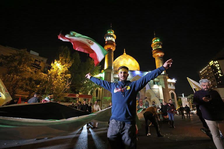 Manifestantes iraníes ondean una bandera palestina mientras se reúnen en la Plaza Palestina de Teherán el 14 de abril de 2024, después de que Irán lanzara un ataque con aviones no tripulados y misiles contra Israel