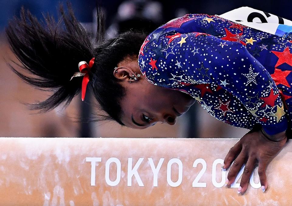 Simone Biles competes on the balance beam in the women's team qualifying Sunday.