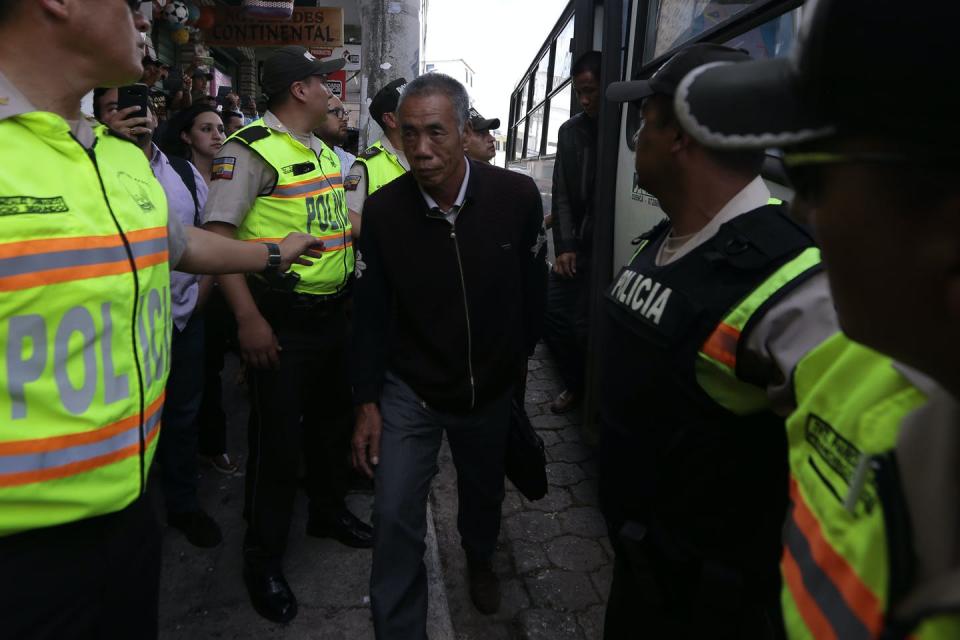 Police escort a man off a bus