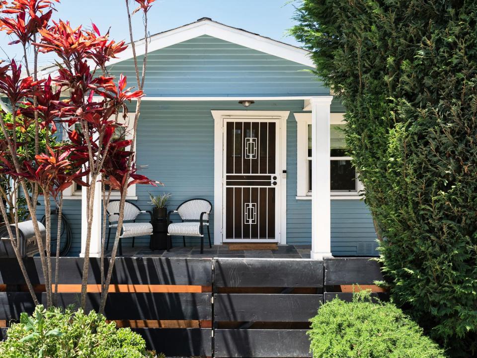 a blue house with a patio and a table and chairs