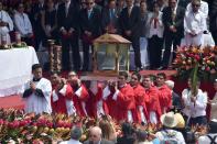 Catholics carry clothes that belonged to late archbishop Oscar Romero during a mass celebrating his beatification at San Salvador's main square on May 23, 2015