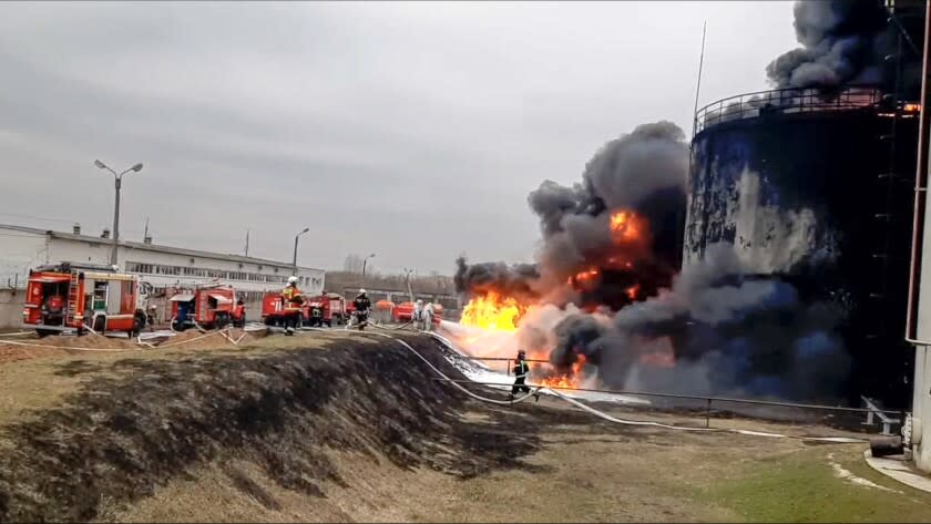 In this handout photo released by Russian Emergency Ministry Press Service on Friday, April 1, 2022, firefighters work at the site of fire at an oil depot in Belgorod region, Russia. The governor of the Russian border region of Belgorod accused Ukraine of flying helicopter gunships into Russian territory and striking an oil depot Friday morning. The depot is run by Russian energy giant Roseneft about 21 miles from the border. The governor says it was set ablaze by the attack that left two people injured. If confirmed, it would be the first attack of its kind by Ukrainian forces inside Russia.(Russian Emergency Ministry Press Service via AP)