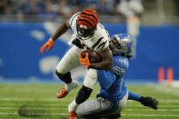 Cincinnati Bengals running back Joe Mixon is tackled by Detroit Lions linebacker Jalen Reeves-Maybin (44) during the first half of an NFL football game, Sunday, Oct. 17, 2021, in Detroit. (AP Photo/Paul Sancya)