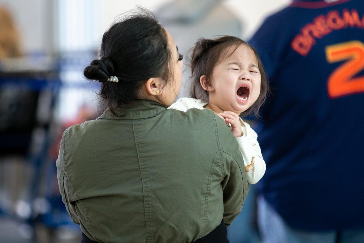 Grace Arguson holds her daughter, Celestine, while they wait for a delayed flight Wednesday at Will Rogers World Airport in Oklahoma City after the FAA had a computer outage grounding flights nationwide.