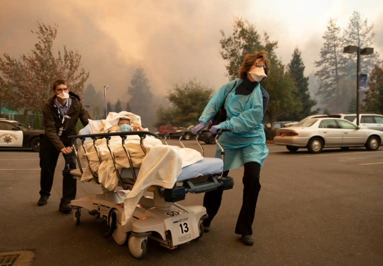 Patients are quickly evacuated from the Feather River Hospital as it burns down during the Camp fire in Paradise, California on November 8, 2018