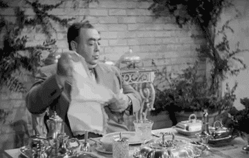 A man tucks a napkin into his shirt collar before eating