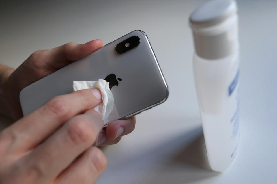 16 March 2020, Bavaria, Kempten: A young man disinfects his smartphone with a paper towel and disinfectant. Photo: Karl-Josef Hildenbrand/dpa (Photo by Karl-Josef Hildenbrand/picture alliance via Getty Images)