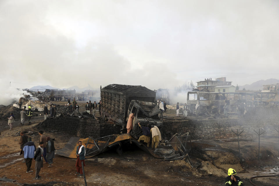 Residents watch burning oil tankers and trucks in Kabul, Afghanistan, Sunday, May 2, 2021. A fire roared through several fuel tankers on the northern edge of the Afghan capital late Saturday, injuring at least 10 people and plunging much of the city into darkness, officials said. (AP Photo/Rahmat Gul)