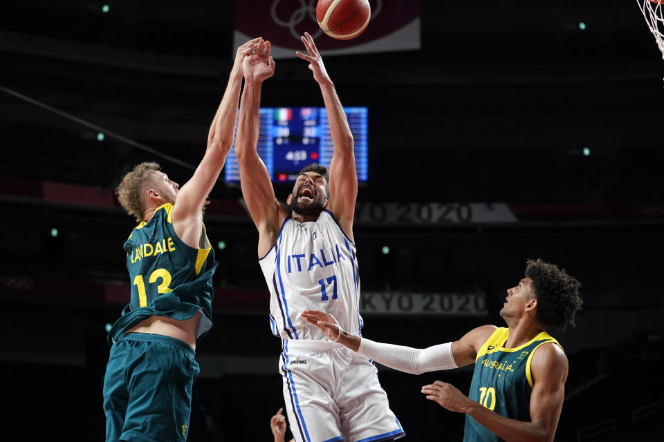 Italy's Giampaolo Ricci (17) fights for a rebound with Australia's Jock Landale (13) and Matisse Thybulle (10) during a men's basketball preliminary round game at the 2020 Summer Olympics, Wednesday, July 28, 2021, in Saitama, Japan. (AP Photo/Charlie Neibergall)