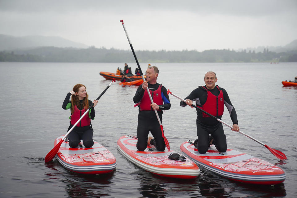 Britain's Liberal Democrat Leader Ed Davey, right, takes part in paddleboarding with local MP Tim Farron and his daughter Gracie on Lake Windermere, in Windermere, England, Tuesday, May 28, 2024, while on the general election campaign trail. (Peter Byrne/PA via AP)