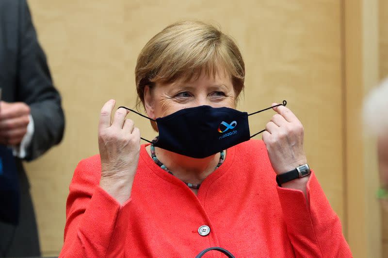 German Chancellor Angela Merkel takes off her face mask during a session at the upper house of the German parliament Bundesrat, following the outbreak of the coronavirus disease (COVID-19), in Berlin