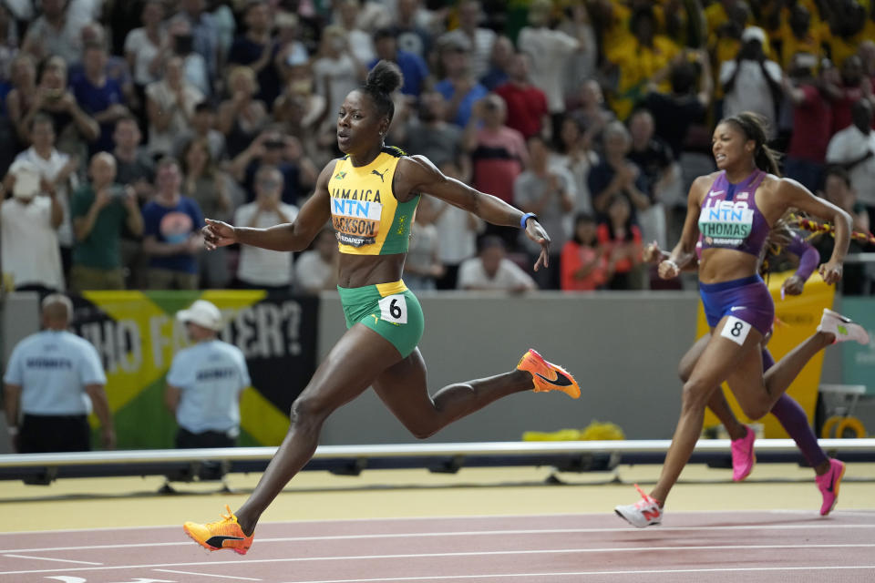 Shericka Jackson, of Jamaica, crosses the finish line ahead of silver medalist Gabrielle Thomas, of the United States to win the gold medal in the Women's 200-meters final during the World Athletics Championships in Budapest, Hungary, Friday, Aug. 25, 2023. (AP Photo/Matthias Schrader)