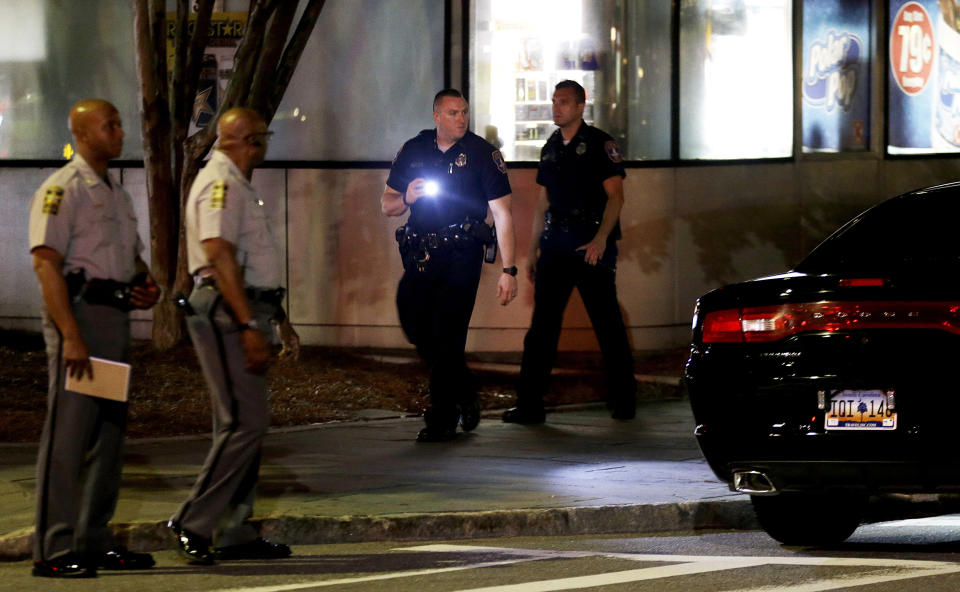 A police officer uses a flashlight while searching the area. (Photo: David Goldman)