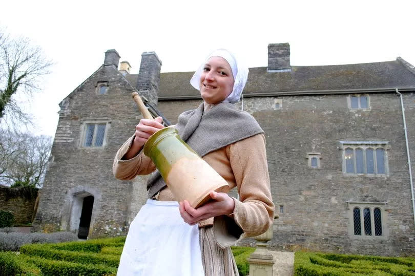 A woman dressed as a servant outside Llancaiach Fawr manor house