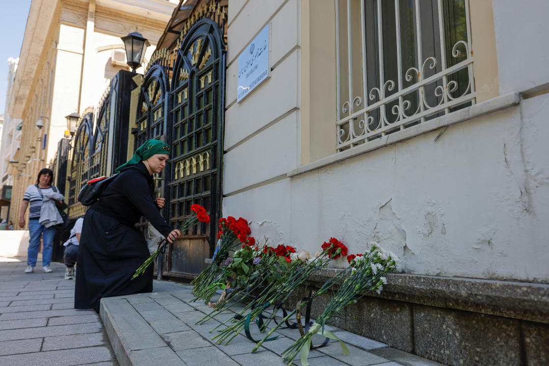 A woman brings flowers to the Iranian embassy to pay tribute to Iran's President Ebrahim Raisi, Foreign Minister Hossein Amirabdollahian and other victims of a recent helicopter crash in mountainous terrain near Iran's border with Azerbaijan, in Moscow, Russia, May 20, 2024. REUTERS/Maxim Shemetov