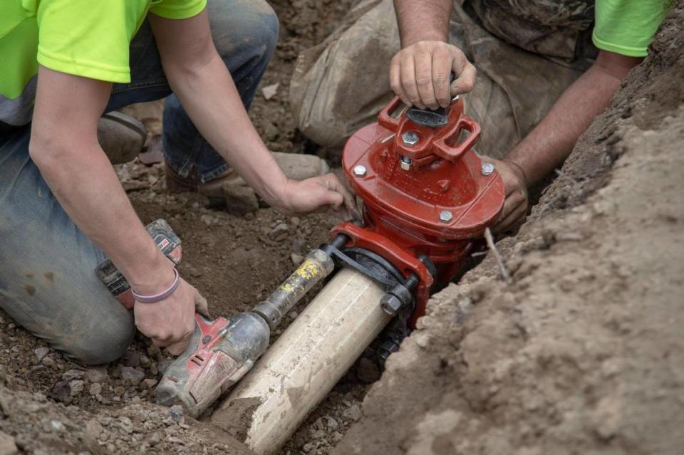 Dillon Flugge and Brenden Wilkens work to repair a water line in Martin County outside Inez, Ky., Wednesday, March 17, 2021.