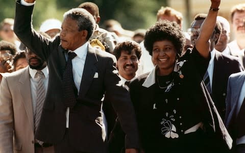 Nelson Mandela and Winnie walking hand in hand, raise clenched fists upon Mandela's release in 1990 - Credit: AP