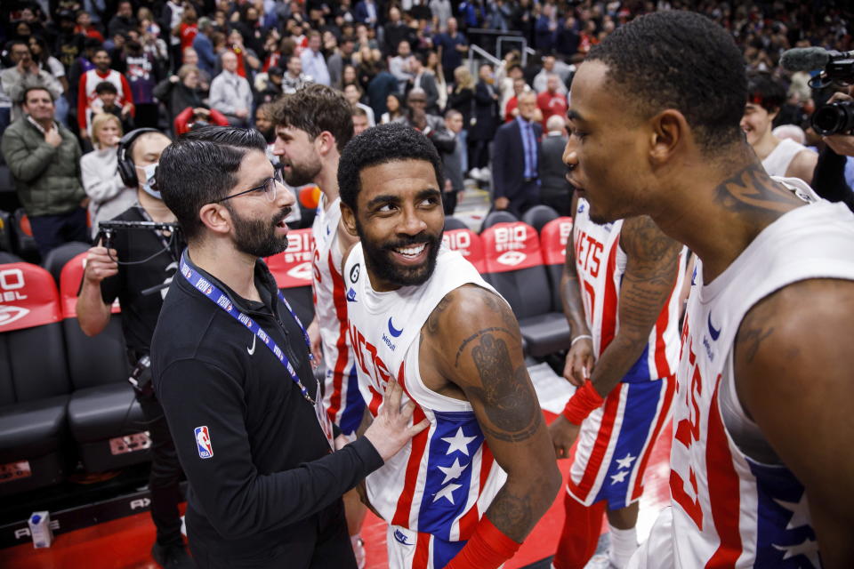 Brooklyn Nets guard Kyrie Irving, second from front left, celebrates with teammates after hitting the winning basket against the Toronto Raptors during an NBA basketball game in Toronto, Friday, Dec. 16, 2022. (Cole Burston/The Canadian Press via AP)