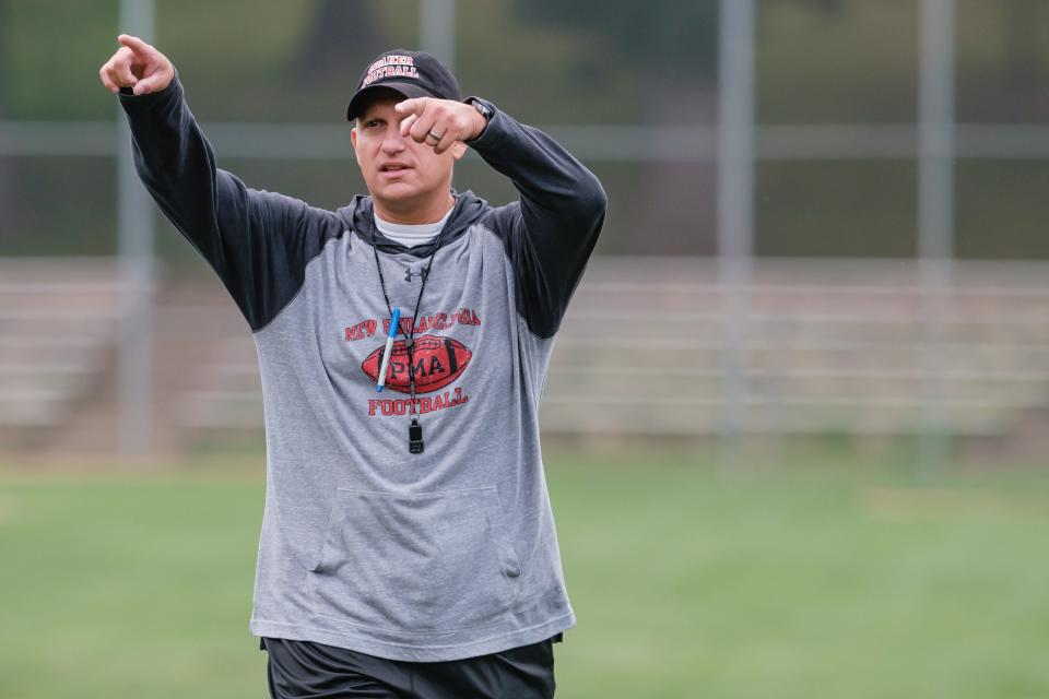 New Philadelphia head coach Mike Johnson instructs during an early Monday morning football practice at Tuscora Park, Aug. 1. The turf at Woody Hayes Stadium was not playable due to current track replacement delays.