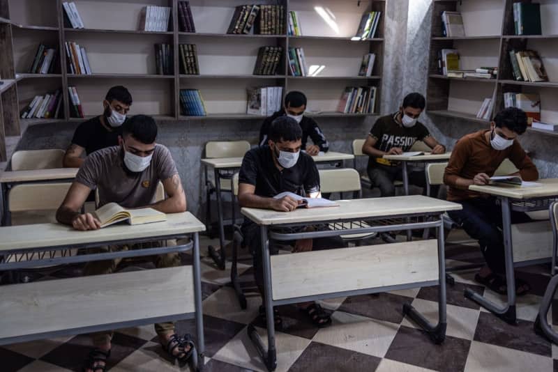 Prisoners sit in the library of the Military Police prison in Aleppo, which is designated for those who were charged with drug-related crimes. Anas Alkharboutli/dpa