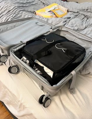 A portable hanging luggage organizer for the ultimate lazy unpacker hack