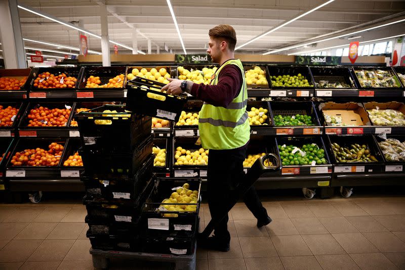 FILE PHOTO: An employee arranges produce inside a Sainsbury’s supermarket