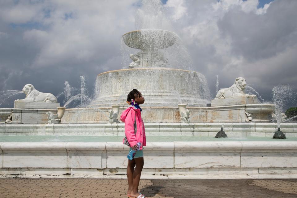 Tyana Poe of Detroit takes in some spray from the Scott Memorial Fountain that opened officially on Belle Isle on May 29, 2020.