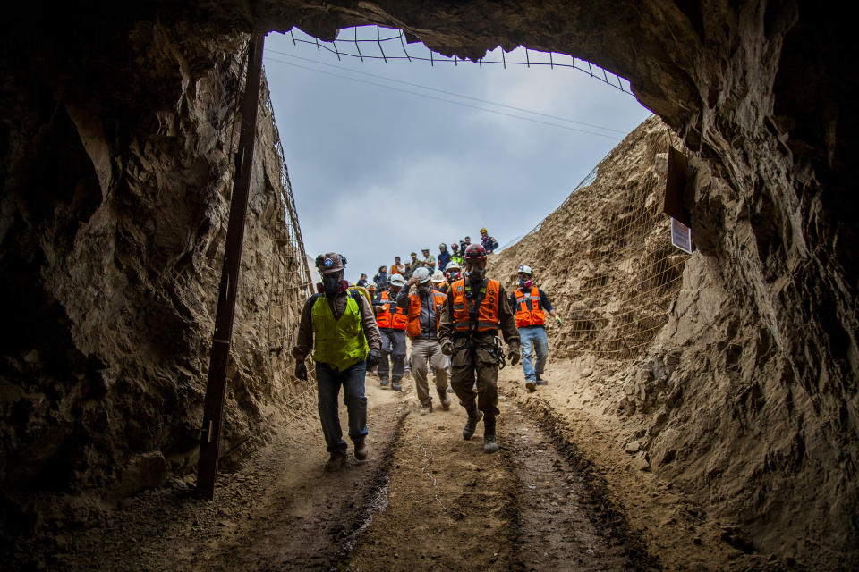 In this photo provided by the regional government of Antofagasta, men enter the San José mine to work on the rescue of three Bolivian miners trapped deep underground since the night before when it collapsed in Tocopilla, Chile, Friday, June 14, 2019. Local authorities confirmed that the men are alive. (Ricardo Rodriguez/Intendencia de Antofagasta via AP)