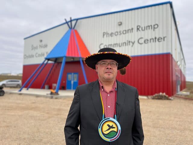 Chief Ira MacArthur stands in front of the Pheasant Rump Nakota Nation's newly built recreation center.  The First Nation is also receiving funding to build a 7,800-square-foot Indigenous cultural center to promote Nakota language and culture, the provincial and federal governments announced earlier this week.  (Louise Page Eagle/CBC - image credit)