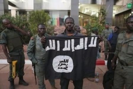 Malian security officials show a jihadist flag they said belonged to attackers in front of the Radisson hotel in Bamako, Mali, November 20, 2015. REUTERS/Joe Penney
