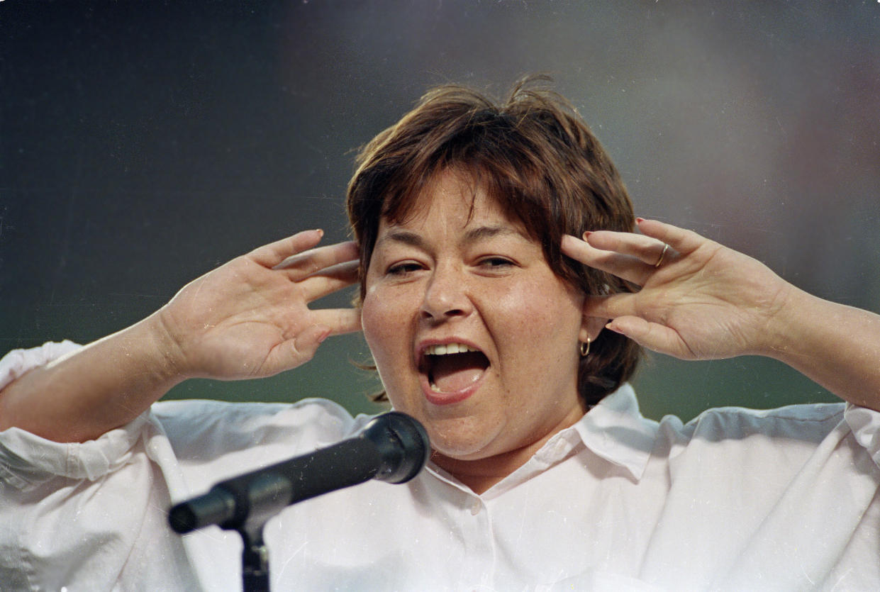 Roseanne Barr holds her fingers in her ears as she screams the national anthem between games of the San Diego Padres and the Cincinnati Reds doubleheader in 1990. She was booed loudly, and she made an obscene gesture and spat when she was finished. (Photo: AP Photo/Joan Fahrenthold)