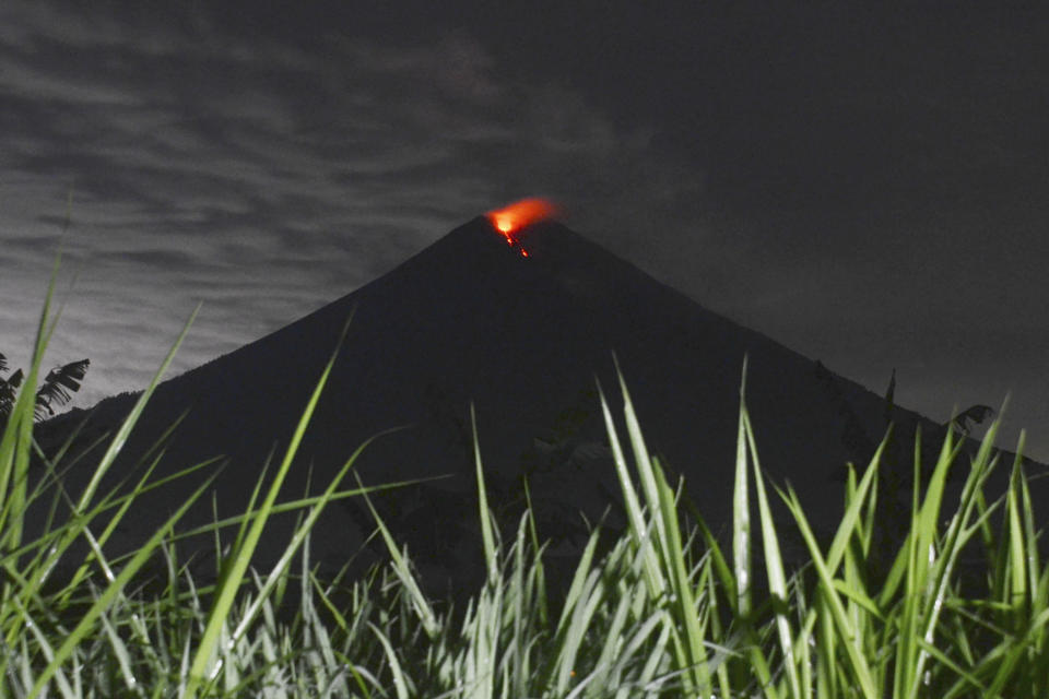 Mount Semeru releases volcanic materials during an eruption as seen from Lumajang district, East Java province, Indonesia, Tuesday, Dec. 7, 2021. The highest volcano on Java island spewed thick columns of ash into the sky in a sudden eruption Saturday triggered by heavy rains. Villages and nearby towns were blanketed by tons of volcanic debris. (AP Photo/Hendra Permana)