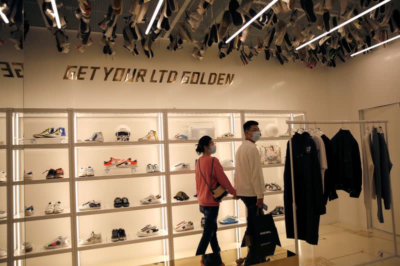 Customers wearing face masks following the COVID-19 outbreak are seen at Italian high fashion sneaker brand Golden Goose in Beijing