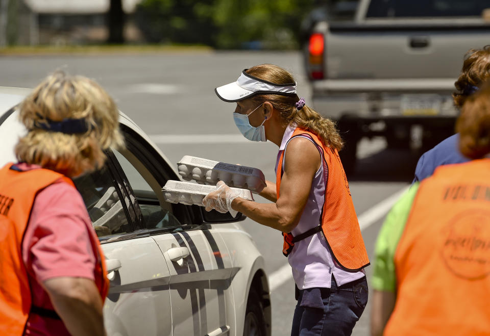 Topton, PA - June 9: Deb White gives out cartons of eggs. At the Brandywine Heights Intermediate and Middle School in Topton Tuesday afternoon June 9, 2020 where Helping Harvest was conducting a food distribution. Helping Harvest has seen an increase in demand for it's services during the coronavirus pandemic. (Photo by Ben Hasty/MediaNews Group/Reading Eagle via Getty Images)