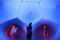 People walk through Exxopolis, an inflatable walk-in luminarium at Grand Park in Los Angeles, California, September 7, 2013. The inflatable walk-in luminarium, designed by Architects of Air, creates a maze of winding paths and domes featuring Islamic architecture, Archimedean solids, and Gothic cathedral designs. REUTERS/Jonathan Alcorn (UNITED STATES - Tags: SOCIETY)