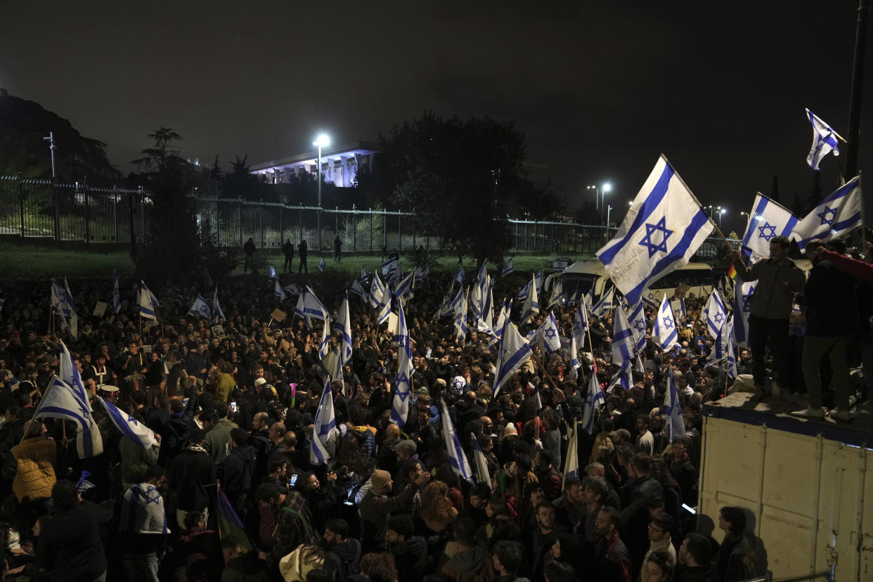 Israelis opposed to Prime Minister Benjamin Netanyahu's judicial overhaul plan protest outside of the Knesset, the country's parliament, after the Israeli leader fired his defense minister, in Jerusalem, Monday, March 27, 2023. Defense Minister Yoav Gallant had called on Netanyahu to freeze the plan, citing deep divisions in the country and turmoil in the military. (AP Photo/ Mahmoud Illean)