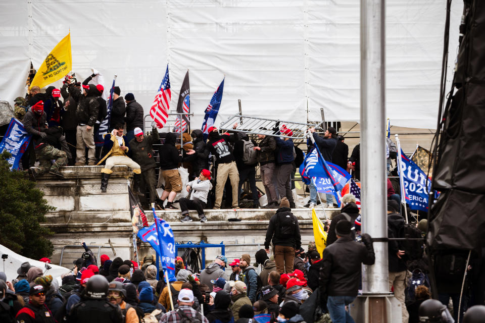 WASHINGTON, DC - JANUARY 06: A group of pro-Trump protesters climb the walls of the Capitol Building after storming the West lawn on January 6, 2021 in Washington, DC. A pro-Trump mob stormed the Capitol, breaking windows and clashing with police officers. Trump supporters gathered in the nation's capital today to protest the ratification of President-elect Joe Biden's Electoral College victory over President Trump in the 2020 election. (Photo by Jon Cherry/Getty Images)