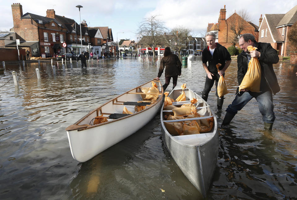 People loads their boats with sandbags on a flooded street, in Datchet, England, Monday, Feb. 10, 2014. The River Thames has burst its banks after reaching its highest level in years, flooding riverside towns upstream of London. Residents and British troops had piled up sandbags in a bid to protect properties from the latest bout of flooding to hit Britain. But the floods overwhelmed their defences Monday, leaving areas including the centre of the village of Datchet underwater. (AP Photo/Sang Tan)