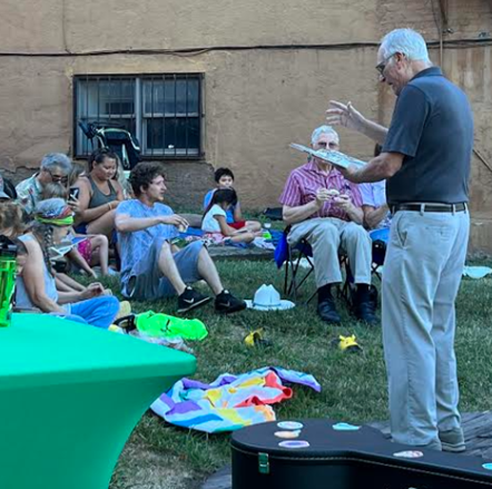 Dr. William E. McCloskey reads to guests at a literacy event held Friday at Altrusa Park.
